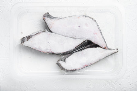 Frozen Greenland halibut steaks vacuum pack set, on white stone table background, top view flat layの写真素材