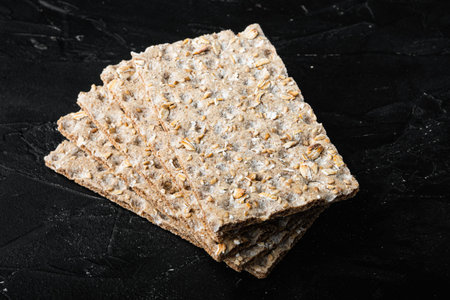 Crunchy crispbread Healthy snack set, on black dark stone table background