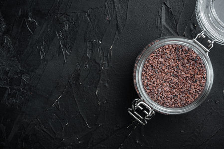 Indian Black salt, Kala namak hindi Healthy food concept set, in glass jar, on black stone background, top view flat lay, with copyspace and space for textの写真素材