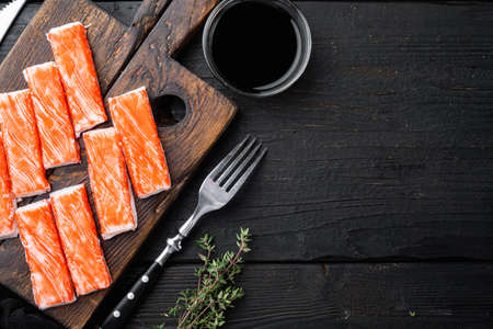 Asian snack surimi set, on wooden cutting board, on black wooden table background, top view flat lay, with copyspace and space for textの写真素材