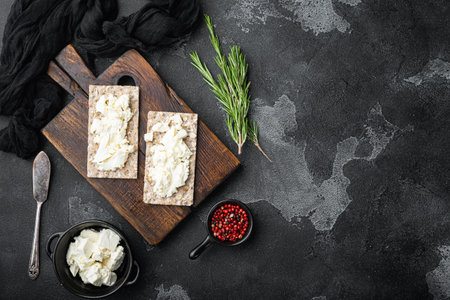 Homemade Crisp bread toast with Cottage Cheese set, on black dark stone table background, top view...