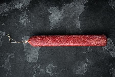 Delicious salami sausage set, on black dark stone background, top view flat lay, with copy space for textの写真素材