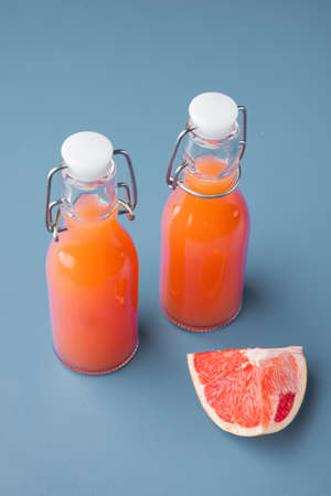 Grapefruit juice and ripe grapefruits set, on blue textured summer backgroundの写真素材