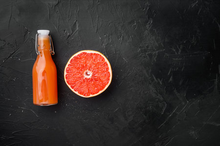 Fresh organic pink grapefruit juice set, on black dark stone table background, top view flat lay, with copy space for textの写真素材