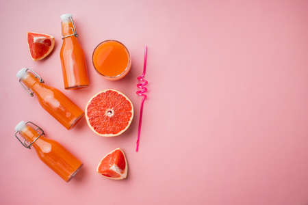 Fresh organic pink grapefruit juice set, on pink textured summer background, top view flat lay, with copy space for textの写真素材