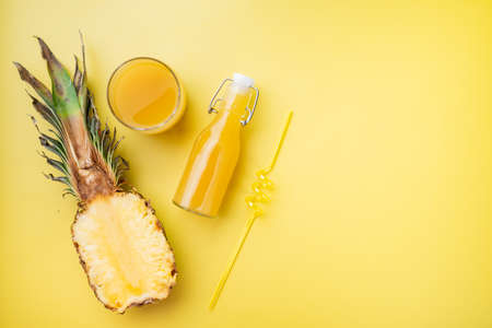 Fresh ripe pineapple and glass of juice set, on yellow textured summer background, top view flat lay, with copy space for textの写真素材
