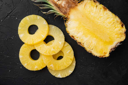 Pineapple cut set, on black dark stone table background, top view flat layの写真素材