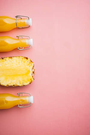 Pineapple fresh juice in glass set, on pink textured summer background, top view flat lay, with copy space for textの写真素材