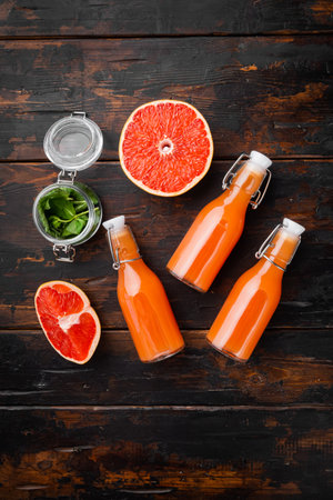 Fresh grapefruits and glass of grapefruit juice set, on old dark wooden table background, top view flat lay, with copy space for textの写真素材