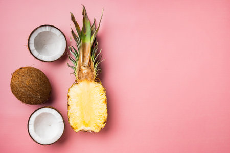 Fresh exotic fruits, pineapple and Coconut set, on pink textured summer background, top view flat...