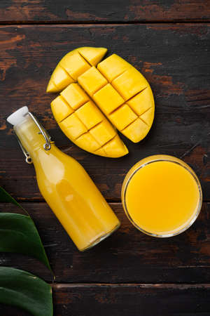 Mango juice set, on old dark wooden table background, top view flat layの写真素材