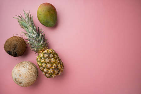 Fresh fruits, pineapple and Coconut set, on pink textured summer background, top view flat lay, with copy space for textの写真素材