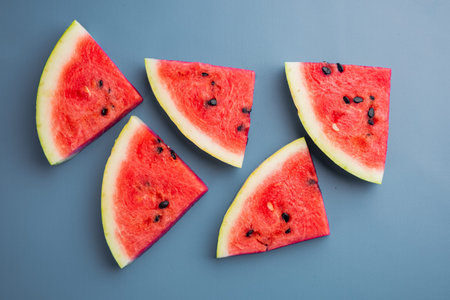 A half of fresh watermelon set, on blue textured summer background, top view flat lay