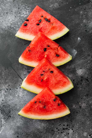 Sliced watermelon set, on black dark stone table background, top view flat layの写真素材