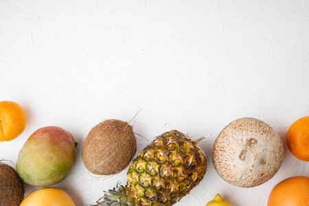 Ripe juicy fresh tropical fruits set, on white stone table background, top view flat lay, with copy...