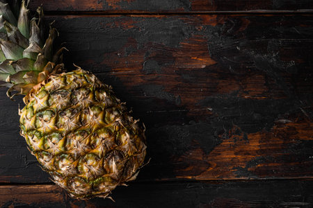 Tasty whole pineapple set, on old dark wooden table background, top view flat lay, with copy space for textの写真素材