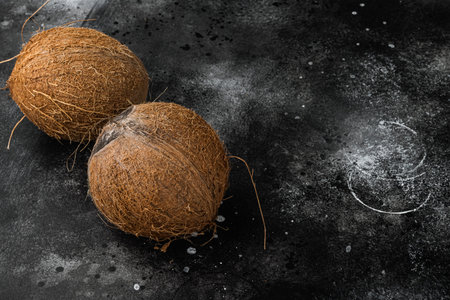 Tropical fruit coconut whole set, on black dark stone table background, top view flat lay, with copy...