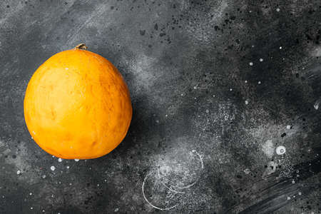 Whole yellow ripe melon set, on black dark stone table background, with copy space for textの写真素材