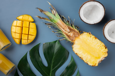Fresh fruits tropical composition set, on blue textured summer background, top view flat lay