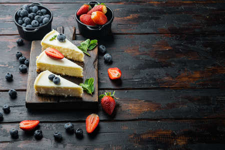 Slices Of Classical New York Cheesecake, on old dark wooden table background with copy space for textの写真素材