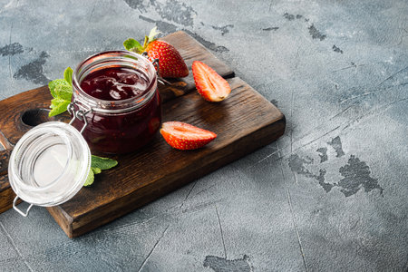 Small glass bowl, of red berry jam, on gray background with copy space for textの写真素材