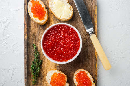 Bruschette with butter red caviar, on white background, top view flat layの写真素材