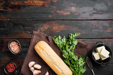 Homemade tasty bread with garlic, and herbs ingredients set, on old dark wooden table background, top view flat lay, with copy space for textの写真素材