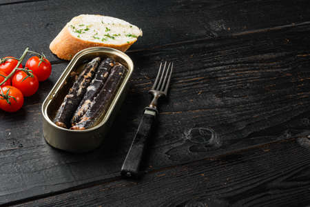 Fish in iron tin can set, on black wooden table background, with copy space for textの写真素材