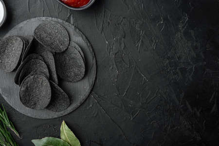 Cheese and chive potato crisp snack set, on black stone background, top view flat lay, with copy space for textの写真素材