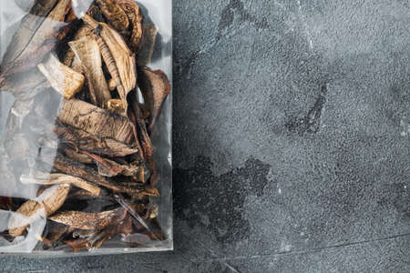 Wild organic dried porcini mushroom set, on gray background, in plastic pack, top view flat lay, with space for text copyspaceの写真素材