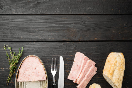 Open pork luncheon meat can with baguette set, on black wooden table background, top view flat lay,...