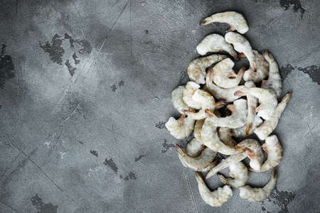 Frozen raw uncooked tiger prawns, shrimps set, on gray stone background, top view flat lay, with copy space for textの写真素材