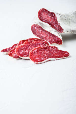 Sliced cuts of longaniza, dry cured spanish sausage on white textured background with space for text.の写真素材