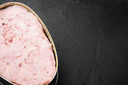 Canned ham set, on black dark stone table background, with copy space for text