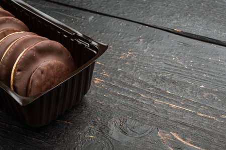 Polish chocolate chip cookies for dessert set, in plastic tray container, on black wooden...