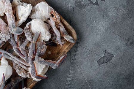 Frozen raw blue swimming crab claws set, on wooden tray, on gray background, top view flat lay, with copyspace and space for textの写真素材