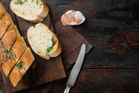 Garlic bread filled compound herb butter set, on old dark wooden table background, top view flat lay, with copy space for textの写真素材