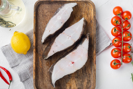 Raw fish cut set, with ingredients and rosemary herbs, on white stone table background, top view...