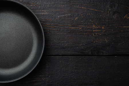 Large frying pan set with copy space for text or food with copy space for text or food, top view flat lay, on black wooden table backgroundの写真素材