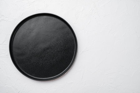 Ceramic empty black plate set, on white stone table backgroundの写真素材