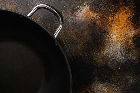 Wok pan empty with copy space for text or food with copy space for text or food, top view flat lay , on old dark rustic table backgroundの写真素材