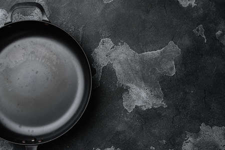 Vintage cast iron skillet with copy space for text or food with copy space for text or food, top view flat lay , on black dark stone table backgroundの写真素材