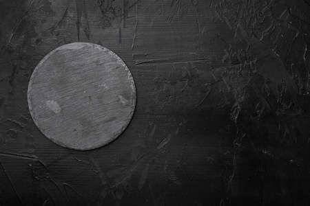 Slate stone cutting board with copy space for text or food with copy space for text or food, top view flat lay , on black dark stone table backgroundの写真素材