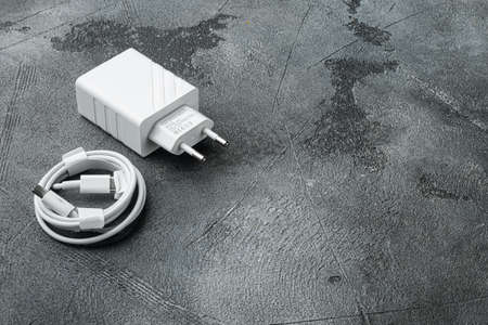 Usb cable with usb wall charger plug set, on gray stone table background, with copy space for textの写真素材