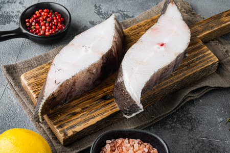 Chilled halibut steaks set, with ingredients and rosemary herbs, on gray stone table backgroundの写真素材