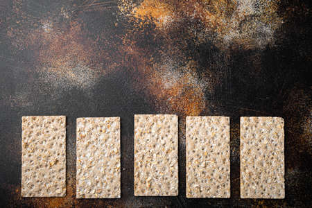Wholegrain Rye Crispbread cracker set, on old dark rustic table background, top view flat lay, with copy space for textの写真素材