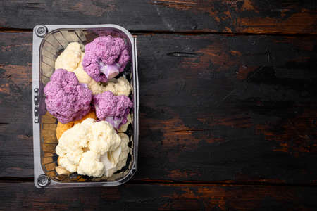 Various sort of cauliflower. Purple, yellow and white set, in container, on old dark wooden table background, top view flat lay, with copy space for textの写真素材