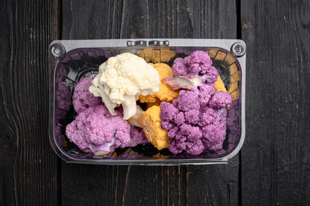 Various sort of cauliflower. Purple, yellow and white set, in container, on black wooden table background, top view flat lay, with copy space for textの写真素材