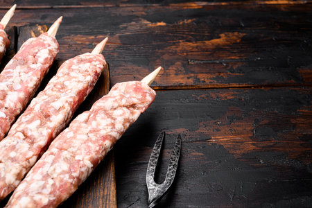Raw beef and lamb meat kebabs sausages set, on old dark wooden table background, with copy space for textの写真素材