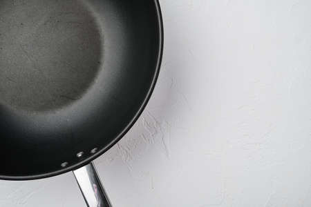 Pan with handle wok set with copy space for text or food with copy space for text or food, top view flat lay, on white stone table backgroundの写真素材